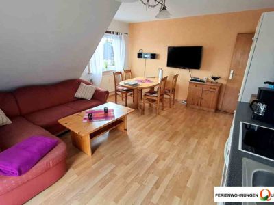 Küchenzeile, Ecksofa, Esstisch, Flat-TV und Radio bietet der Wohnraum der Fereinwohnung 2 der Pension Quellenhof in Altenau im Oberharz