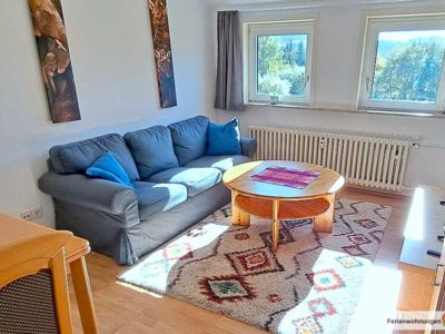 Der Wohnraum in der Ferienwohnung 7 mit Sofa, Tisch, Wohnwand mit Sat-TV und Essecke mit Tisch und 2 Stühlen