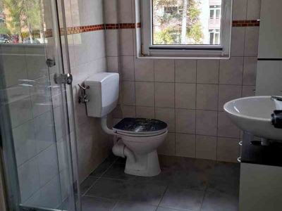 Blick in das Badezimmer der Ferienwohnung 8 im Haus Celina. Mit Dusche, WC und Waschtisch mit Unterschrank.