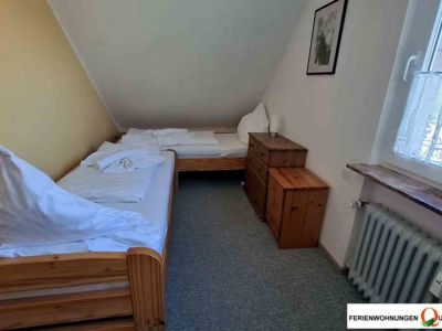 Zwei Einzelbetten im dritten Schlafzimmer der Ferienwohnung 5 im Haus Celina der Pension Quellenhof in Altenau, Kreis Goslar.
