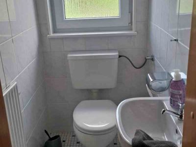 Helles Gäste-WC der Ferienwohnung 2 der Pension Quellenhof im Ort Altenau im Oberharz. Ideal für einen Urlaub im Harz.