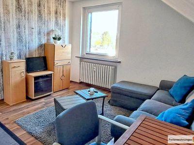 Gemütlicher Wohnraum mit Sofa, Couchtisch und einem Esstisch und 2 Stühlen