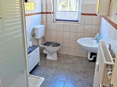 Daas Bad in der ferienwohnung 8 im haus Celina bietet Dusche, WC, Waschbecken mit Spiegelschrank und einen Unterschrank