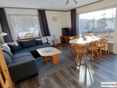 Das großzügige Wohnzimmer der Ferienwohnung mit viel Platz und dem Zugang zum Balkon